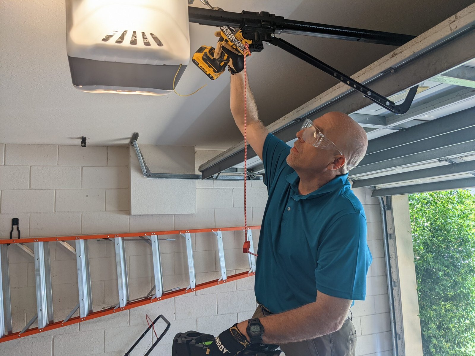 Certified Garage Door Technician from Rocket Estate Builders servicing an older garage door opener in Central Florida